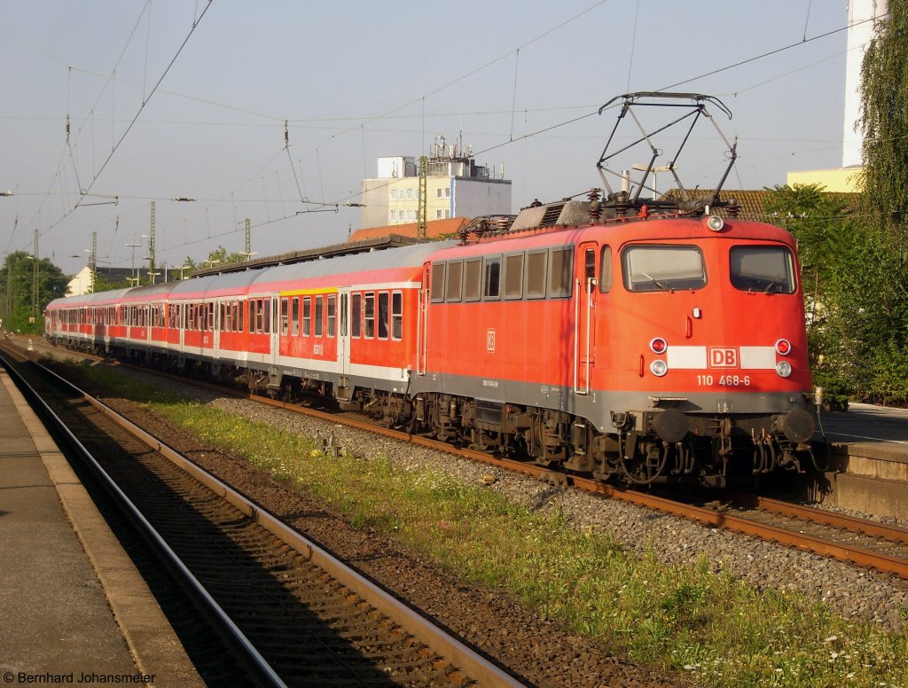 Mit dem Fuballsonderzug fr Arminia Bielefeld ist 110 468-6 von Herford (Lr Minden - Herford) nach Koblenz unterwegs und hlt hier am Morgen in Gtersloh. August 2009 