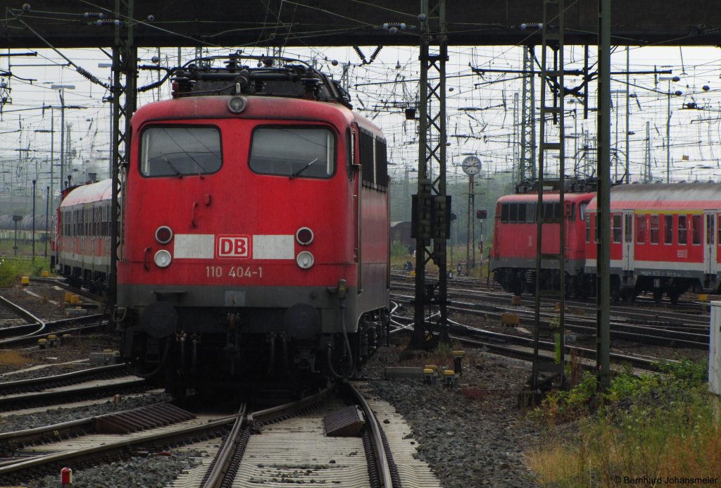 Von einer Rangierlok wird 110 404-1 mit dem leeren Wagenpark in den Abstellbereich gezogen, whrend eine weitere 110er den Gieener Bahnhof mit der RB 30 nach Friedberg verlsst. Juli 2010