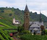 Zwischen den Weinbergen und Kirchen von Hatzenport fhrt 140 716-2 mit einem Gterzug durchs Moseltal Richtung Trier.