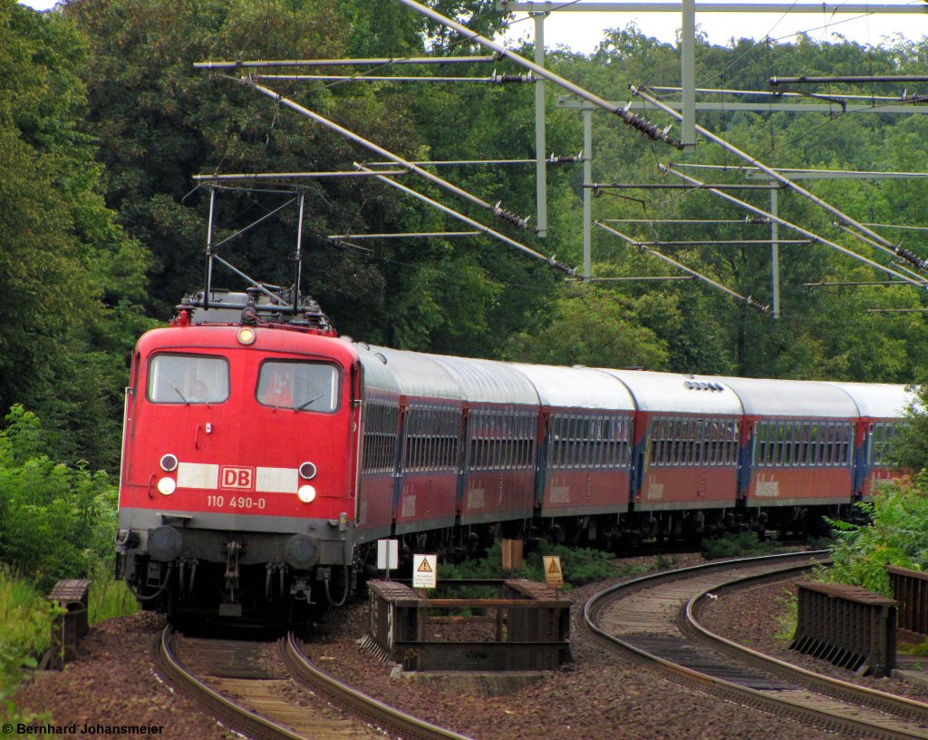 Mit dem Leerzug fr den Kreuzfahrersonderzug von Potsdam nach Warnemnde kommt 110 490-0 vor dem S-Bahnhof Berlin Nikolassee aus dem Grunewald um die Kurve. August 2011