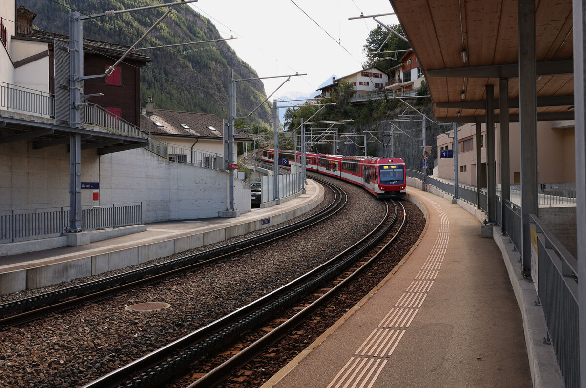 Abstieg eines MGB-Zuges von Zermatt her nach Stalden. Im späten Abendlicht fahren die beiden Triebzüge ABDeh4/8 2022 und 2026 von Zermatt her in den Bahnhof Stalden ein. 30.August 2025 