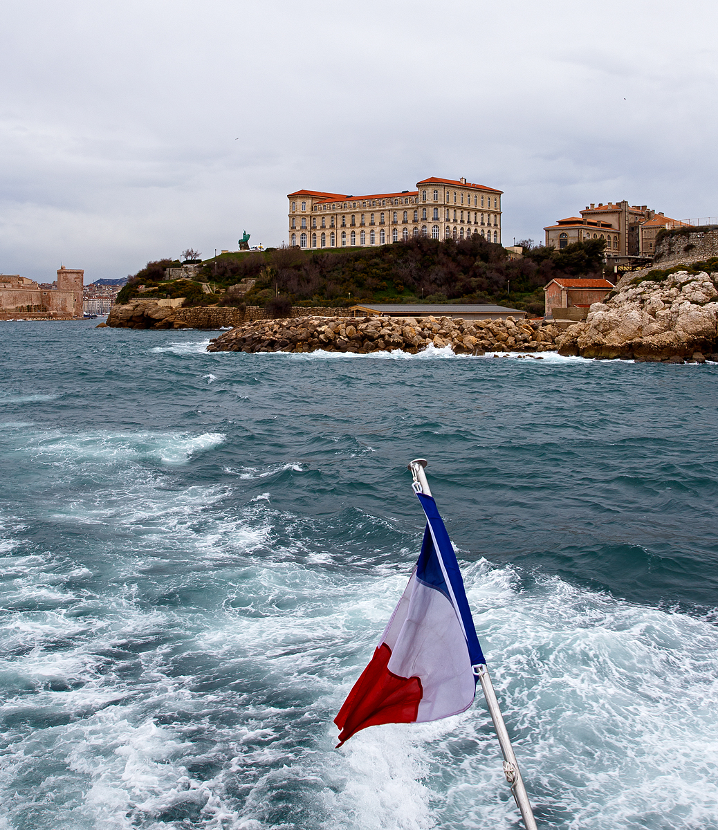Das Palais du Pharo in Marseille am 25.03.2015 von der Seeseite.

Der Palast wurde ab 1858 von Napoleon III. (Geburtsnamen Charles-Louis-Napoléon Bonaparte) für seine Frau Eugénie de Montijo erbaut. Napoleon III. war von 1852 bis 1870 Kaiser der Franzosen, er war der Neffe von Napoleons I. (Napoleon Bonaparte).Napoleon der III. hatte übrigens 1867 die Annexion Luxemburgs geplant die aber ja bekanntlich scheiterte.

Das Palais liegt gegenüber dem Fort Saint-Jean mit Blick auf den Hafen und der Bucht von Marseille. Beim Sturz von Napoleon III. im Jahr 1870 war der Palast nach zwölf Jahre Bauzeit noch nicht fertiggestellt, so hat das Kaiserpaar dort nie gelebt.

Nach dem Sturz des Regimes griffen Gegner Napoleons III. Symbole des Imperiums an; insbesondere zerstörte die Menge napoleonischen Embleme und Ornamente, die die Fassade des Gebäudes schmückten.

Als der ehemalige Kaiser 1973 starb, reichte die Stadt Marseille Klage gegen die ehemalige Kaiserin ein. Dies führt zu einem Prozess, an dessen Ende Eugenie 1884 beschloss, das Schloss und seine Gärten der Stadt anzubieten, sofern sie für gemeinnützige Zwecke genutzt werden.
