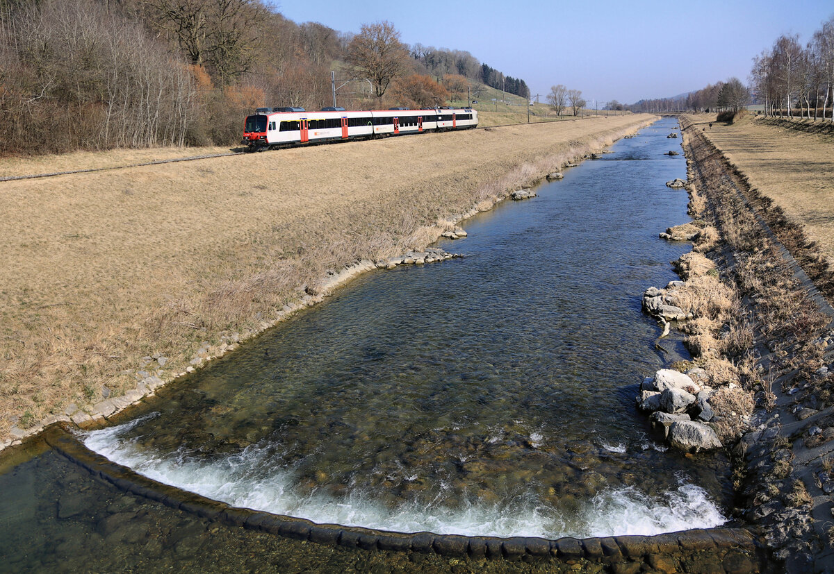 Der Broye entlang bei Moudon. Diese Begradigung des Flusses ermöglichte eine erhebliche Ausweitung der landwirtschaftlichen Nutzungsfläche und entstand im wesentlichen zwischen 1892 und 1906. Nebenher eine S8 Richtung Payerne, 10.März 2022  