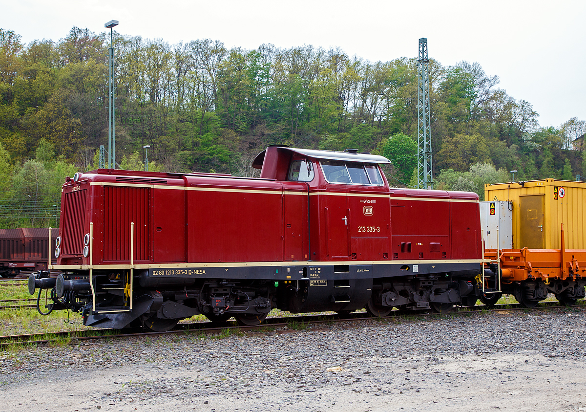Die 213 335-3 (92 80 1213 335-3 D-NESA), der NeSA Eisenbahn-Betriebsgesellschaft Neckar-Schwarzwald-Alb mbH (Rottweil), ex DB V 100 2335, ist am 29.04.2022, mit der SPENO Schienenschleifeinheit RR 16 MS-6 (99 84 9127 001-8 NL- SPENO) und dem zugehörigen Schutzwagen 31 85 3936 163-0 CH-WASCO, der Gattung Res, beladen mit Werkstatt- und Aufenthaltscontainern, in Betzdorf (Sieg) abgestellt.

Die Steilstrecken V 100.20 wurde 1966 von Maschinenbau Kiel GmbH (MaK) unter der Fabriknummer 1000382 gebaut und als V 100 2335 an die Deutsche Bundesbahn geliefert, zum 01.01.1968 erfolgte dann die Umzeichnung in DB 213 335-3 und als diese fuhr sie bis zur Ausmusterung 1999. Bereits 2000 ging sie an die NeSA.

Die Baureihe V100.20 (spätere 212) ist die leistungsstärkere Variante der V 100. Sie war im Gegensatz zur im Nebenbahndienst eingesetzten V 100.10 auch für den Haupt- und Steilstreckendienst vorgesehen. Bis 1966 wurden insgesamt 381 Exemplare in Dienst gestellt. Um auch auf den damals noch vorhandenen Steilstrecken die Dampfloks ganz ersetzen zu können, benötigte die DB eine Reihe von Lokomotiven, die den speziellen Betriebsvorschriften für Strecken mit mehr als 40 ‰ Gefälle genügten. Hauptforderung war ein unabhängiges zweites Bremssystem, das in diesem Falle durch eine hydrodynamische Bremse realisiert wurde. Das dafür benutzte Getriebe ist dann auch der Hauptunterschied zur V100.20. Ebenfalls geändert wurde die Kühlanlage, um die beim Bremsen entstehende Wärme abführen zu können. Der Hilfsdiesel musste Platzgründen wegfallen. Zehn Lokomotiven, aus der letzten Serie von 150 Maschinen, wurden so gebaut.

Trotz der Unterschiede zur V100.20 wurden die Steilstreckenloks zunächst gemeinsam mit diesen eingenummert. Erst als 1968 die Baureihenbezeichnung in 212 geändert wurde, erhielten die zehn Steilstreckenloks die neue Baureihenbezeichnung 213. Die Ordnungsnummern wurden jedoch beibehalten, wodurch die Verwandtschaft noch heute deutlich wird.

TECHNISCHE DATEN:
Spurweite 1.435 mm
Achsfolge B´B´
Länge über Puffer: 12.300 mm
Drehzapfenabstand: 6.000 mm
Achsabstand im Drehgestell: 2.200 mm
Treibraddurchmesser:  950 mm (neu)
größte Breite: 3.115 mm
größte Höhe über Schienenoberkante: 4.275 mm
kleinster befahrbarer Gleisbogen: 100 m
Dienstgewicht: 64 t
Dieselmotor: V-12-Zylinder 4-Takt Dieselmotor mit Vorkammereinspritzung, Typ MTU 12V652 TA/TZ10
Motorleistung: 1.350 PS (994 kW)
Motordrehzahl: 1.500 U/min
Anfahrzugkraft: 177 kN
Getriebe: Voith L620brs
Höchstgeschwindigkeit: 100 km/h (Streckengang) / 65 km/h (Rangiergang) 
Kraftstoffvorrat: 2.270 l