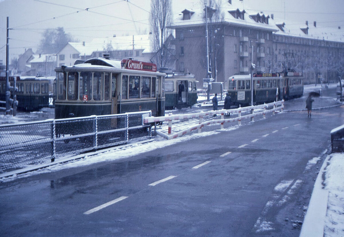 Die alten Berner Zweiachs-Anhänger: Der Ersatzwagen 224 (für die kleinen geschlossenen Wagen 221-226 von 1905, gebaut 1935) wartet in der leicht abfallenden Abstellanlage der ehemaligen Endstation Ostring. Sobald der alte Tramzug ausgefahren und der Standard-Tramzug 129-340 in die Haltestelle eingefahren ist wird 224 handgebremst an den Anhänger 340 herangefahren zur Bildung eines Dreiwagenzugs Be4/4+B4+B2. 22.November 1965 