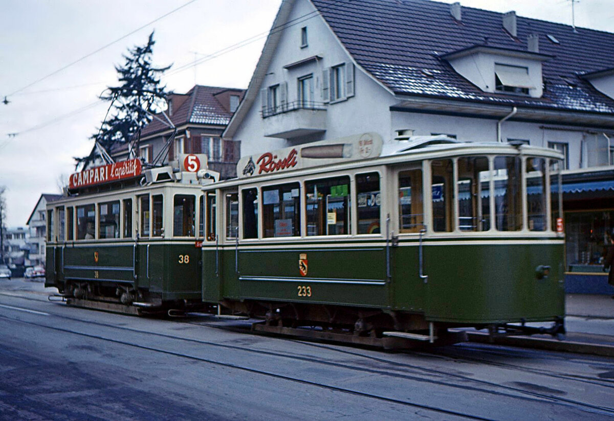 Die alten Berner Zweiachs-Anhänger: Vorserien-Anhänger 233 aus dem Jahr 1912. Gut sichtbar das noch schwach gewölbte Dach. Der Wagen befindet sich in einem Supplementkurs, der am Mittag Ostring mit Wabern verband. Da er vom Ostring kam, trägt er die Routentafel 5. Im Bild fährt der Tramzug unerwartet ohne Halt (deshalb die leichte Unschärfe) von Wabern her zurück zum Depot Burgernziel. Gurtenbahn, 30.November 1966. Wagen 233 blieb bis zum Ende des Einsatzes von Zweiachsern 1973 bestehen.    