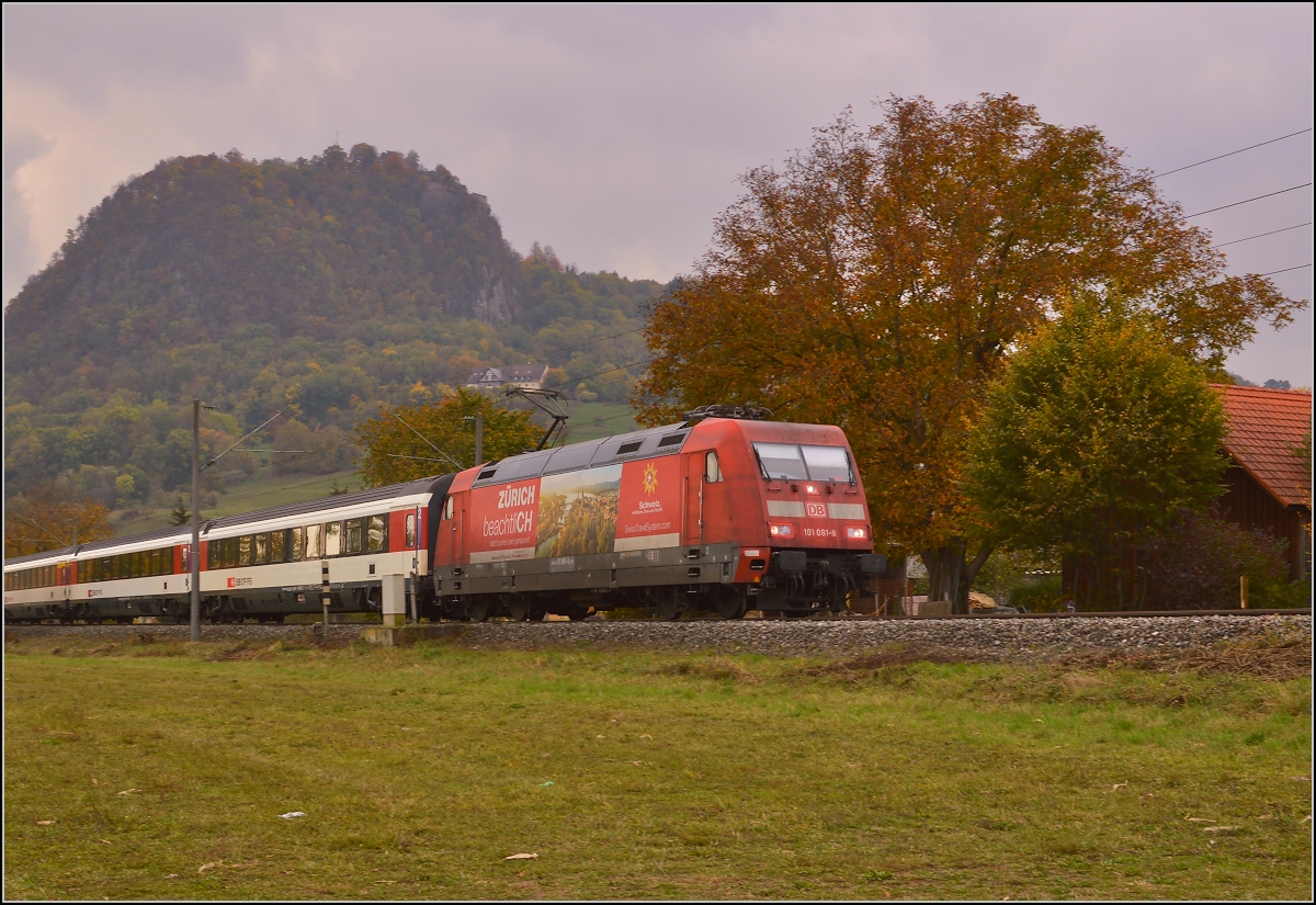 IC 280 verlässt Singen und den Hohentwiel im Hintergrund. Woher der Zug kommt, steht freundlicherweise auf der Lok schon angeschrieben. Nur der Schmutz auf der Lok steht wohl weniger für Abfahrts- und Ankunftsort, sondern für eine Zumutung aus dem Ort der Bahnverwaltung, wo Kehrwoche und Ähnliches wohl weniger bekannt sind... Oktober 2015.