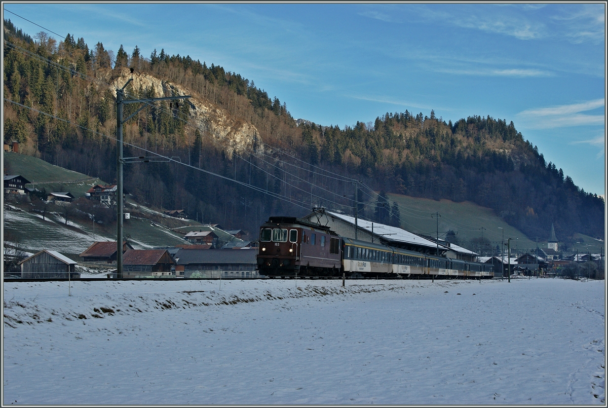 Im noch schattigen Simmental zieht bei Boltigen die BLS Re 4/4 163 ein  GoldenPass  IR Richtung Zweisimmen. 
