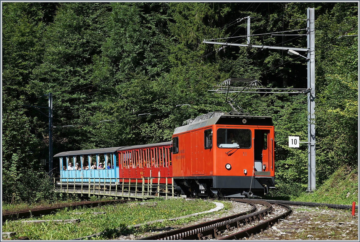 Mit offener Tür, die dann auf Wunsch der Fotografen geschlossen wurde, erreicht der Hem 2/2 N° 11 mit seinen historischen  Belle Epoque Zug  Le Tremblex.
14. Aug. 2017