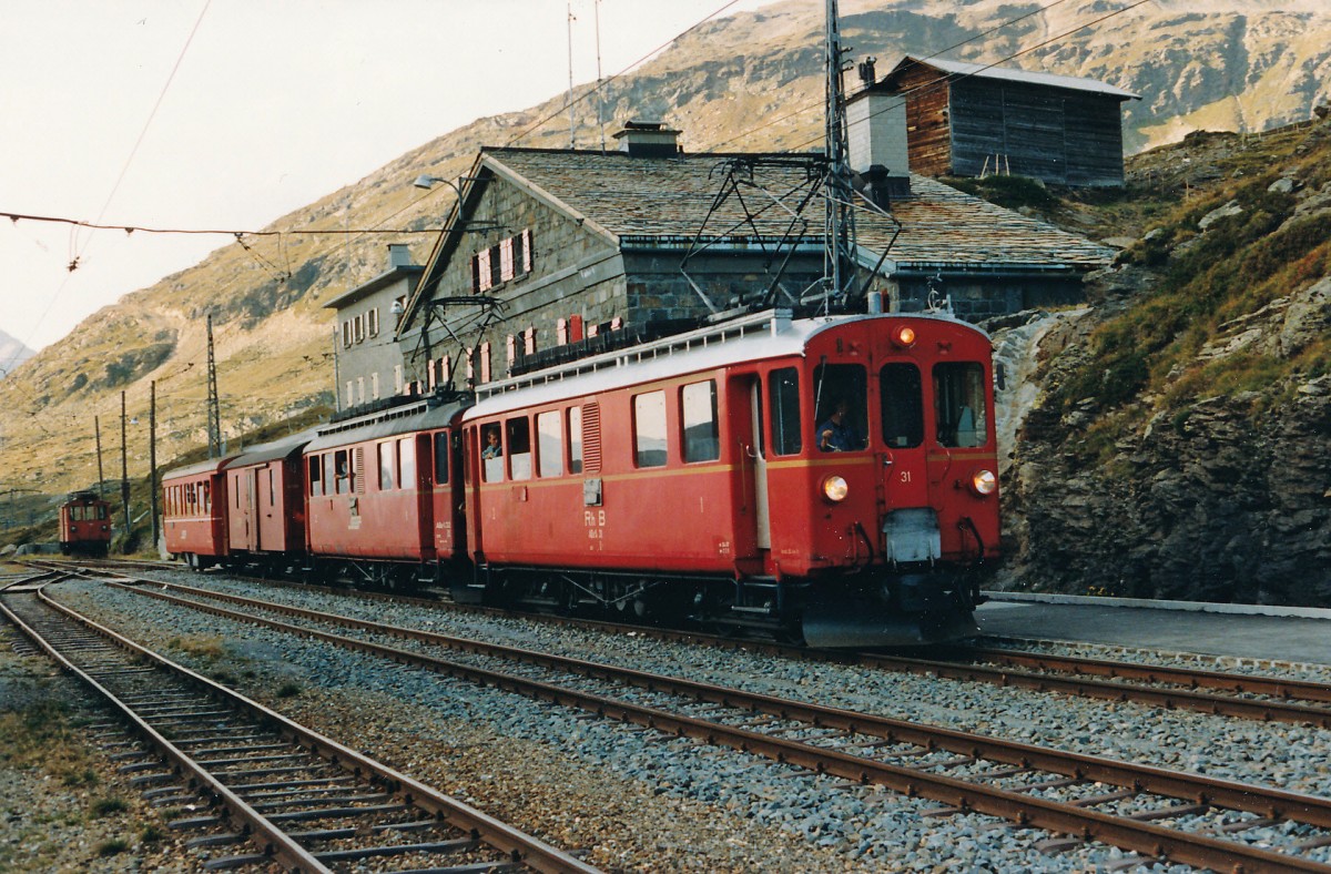 RhB: Am 7. Oktober 1987 wurde der erste Planzug St. Moritz-Tirano mit den ABe 4/4 31 und ABe 4/4 32 geführt. Da es an diesem Tag keine Güterlast zu befördern gab, wurde der Bahnhof Ospizo Bernina vorzeitig erreicht. Damit die Fahrt planmässig fortgesetzt werden konnte, gönnte sich das Bahnpersonal eine Pause im Restaurant, die der Bahnfotograf als Fotohalt nutzte. Auch reichte die Zeit noch für einen Schwatz mit dem freundlichen Lokführer. Das waren noch Zeiten.......
Foto: Walter Ruetsch   
