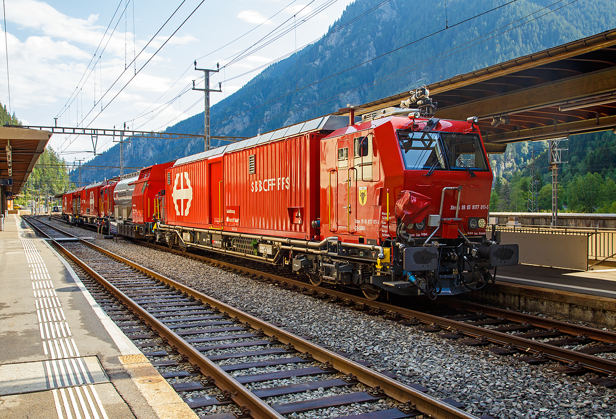 Von der anderen Seite....

Der Erstfelder SBB Lösch- und Rettungszug 2014 „Uri“ (ein vierteiliger LRZ 14) am 02.08.2019 beim Halt im Bahnhof Göschenen.
Der Lösch- und Rettungszug wurde 2014 für die SBB Infrastruktur, Depot Erstfeld, gebaut und besteht aus dem:
Gerätefahrzeug - Xtmas 99 85 9177 011-5 CH-SBBI;
Tanklöschwagen - Xans 99 85 9375 011-5 CH-SBBI;
Rettungsfahrzeug 2 - Xtmas 99 85 9174 011-8 CH-SBBI; sowie
Rettungsfahrzeug 1 - Xtmas 99 85 9174 021-7 CH-SBBI;

Die vorletzte Generation der Lösch- und Rettungszüge (LRZ 2014) ist vierteilig und besteht aus einem Tanklöschwagen, einem Gerätefahrzeug und zwei Rettungsfahrzeugen. Der Antrieb erfolgt mit je zwei MTU-Dieselpowerpacks (6-Zylinder Turbo geladener Dieselmotor von MTU, Partikelfilter, Turbogetriebe mit eingebauten Retarder und Kühlsystem) nach EU-Abgas-Emissionsstufe IIIA Norm, mit je 390 kW Leistung über die beiden Rettungs- sowie das Gerätefahrzeug. Der Lösch- und Rettungszug hat so eine installierte Gesamtleistung von 2.340 kW, eine Höchstgeschwindigkeit von 100 km/h und kann Anhängelasten von 940 Tonnen bei einer Steigung von 27 Promille bewegen. Der gesamte Atemluftvorrat des Zuges beträgt 1.980.000 Normliter und wird in 132 Speicherflaschen, die ein Volumen von 50 Litern haben, mit 300 Bar Druck gelagert. An verschiedenen Orten in den Innenräumen und auf den Plattformen sind Anschlüsse für die Atemluftversorgung vorhanden. Daran können separate Atemschutzmasken oder das tragbare Atemschutzgerät mit Geber- und Nehmerschlauch angeschlossen werden. Alle Führerstandkabinen sind druckdicht und verfügen über eine Atemluftversorgung, welche einen Überdruck erzeugt. In den Führerstandkabinen des Gerätefahrzeugs und des Tanklöschwagens ist zusätzlich ein Bedienpult für die Feuerlöschtechnik eingebaut.
Zwischen 4 und 5 Stunden ist ein autonomer Betrieb des LRZ möglich.

Im Einsatz wird der Zug in zwei Einheiten geteilt. Die erste Einheit aus Gerätefahrzeug und Tanklöschwagen dient der Feuerbekämpfung und dem Bergungsarbeiten. Die zweite Einheit, bestehend aus zwei Rettungsfahrzeugen übernimmt im Shuttleverkehr den Personentransport zu einem sicheren Ort.

Für den Gotthard-Basistunnel (GBT) werden zwei dieser LRZ 14 vorgehalten, dieser steht beim neuen Erhaltungs- und Interventionszentren (EIZ) Erstfeld und ein weiterer beim EIZ Biasca. Für jeden Zug wird rund um die Uhr (7x24 h) eine Besatzung mit je 5 Mann vorgehalten. Die Mannschaften der Lösch- und Rettungszüge sind an deren Standorten kaserniert. Das ermöglicht, dass sie auch in der Nacht innerhalb weniger Minuten einsatzbereit sind. Die Züge sind innerhalb 5 Minuten startklar. Im Ereignisfall erfolgt dann eine entsprechende Verstärkung durch externe Einsatzkräfte, wie Feuerwehr, Sanität, etc..

Technische Daten Rettungsfahrzeug 1 und 2:
Ausrüstung Rettungscontainer:
Außenluftunabhängiger Hauptraum mit leichtem Überdruck, zugänglich durch Schleusenraum;
Platz für etwa 60 Personen oder 40 Personen und 6 Liegen
20 Atemschutzgeräte mit angeschlossenem Geber- und Nehmerschlauch
Tragbahren faltbar, Rettungsbretter, Schaufelbahren, Vakuummatratzen
Material für lebensrettende Sofortmaßnahmen und Sanitätsmaterial
Anschlüsse für die Versorgung von Patienten mit Medizinsauerstoff
Raumüberwachungsgeräte für Sauerstoff und Kohlendioxid
Brandschutzausrüstung der Mannschaft (Jacken, Hosen, Stiefel, Helme)
Explosionsmessgerät und Wärmebildkameras
Ausrüstung Rettungsplattform
Treppenmodul2 Schwenkarme mit Kettenzug
2 Feste LED Scheinwerfer
Prüf- und Erdungsgarnituren für die Fahrleitung

TECHNISCHE DATEN (Fahrzeug):
Hersteller Basisfahrzeug: Windhoff Bahn- und Anlagentechnik GmbH
Basisfahrzeug Typ: WINDHOFF MPV
Hersteller Rettungscontainer und Atemluftanlage: Dräger Safety AG
Spurweite: 1.435 mm (Normalspur)
Achsfolge: Bo´Bo´
Eigengewicht: ca. 70.000 kg
Max. Zuladung: 7.000 kg
Länge über Puffer: 22.060 mm
Drehzapfenabstand: 15.500 mm
Achsabstand im Drehgestell: 2.600 mm
Treibraddurchmesser: 920 mm (neu)
Höhe der Containerauflage: 1.220 mm
Höchstgeschwindigkeit: 100 km/h (eigen und geschleppt)
Leistung: 2 x 390 kW
Dieselmotor: 2 x MTU-Dieselpowerpack (6-Zylinder Turbo geladener Dieselmotor von MTU, Partikelfilter, Turbogetriebe mit eingebauten Retarder und Kühlsystem)
Kleinster befahrbarer Gleisbogen: R 120 m

Technische Daten Tanklöschwagen:
Ausrüstung Tanklöschwagen:
1 Frontmonitor an Führerkabine, Leistung 800 l/Min. bei 8 Bar, Wurfweite ca. 35 m (Wasser)
1 Wasser-/Schaumwerfer auf Kabinendach, Leistung 2400 l/Min. bei 8 Bar, Wurfweite ca. 70 m (Wasser), ca. 60 m (Schaum)
Fahrzeugfront, Selbstschutzdüsen 2 × 75 l/Min. und 1 × 150 l/Min.
Abgänge getrennt für Wasser – Wasser/Schaum
Aufbaubarer Wasser-/Schaumwerfer mit 1200 l/Min.
Aufbaubare Hydroschilder mit 720 und 1800 l/Min.
feste LED-Scheinwerfer
Schlauchmaterial 1.000 m (Schlauchgrößen 40 mm, 55 mm, 75 mm)
Teilstücke, Hohlstrahlrohre, Schwer- und Kombischaumrohre
Handfeuerlöscher (Schaum, CO2)
Prüf- und Erdungsgarnituren für die Fahrleitung

Maschinenraum Tanklöschwagen:
Dieselmotor Deutz (238 kW / 324 PS), 6 Zylinder mit vollautomatischem Partikelfilter welcher die Abgasnorme Stage IIIB erfüllt und angeflanschtem Pumpenaggregat von Vogt
Druckpumpe 6000 l/Min. bei 10 Bar
Schaummittelpumpe 500 l/Min., 0–6 % Zumischrate
Hochdruckpumpe 500 l/Min. bei 40 Bar

TECHNISCHE DATEN (Fahrzeug):
Hersteller Untergestell: Josef Meyer AG
Hersteller Fahrzeug Oberbau: Windhoff Bahn- und Anlagentechnik GmbH
Hersteller Atemluftanlage: Dräger Safety AG
Hersteller Feuerlöschtechnik: Vogt AG
Spurweite: 1.435 mm (Normalspur)
Anzahl der Achsen: 4 in zwei Drehgestellen
Länge über Puffer: 17.040 mm
Drehzapfenabstand: 12.000 mm
Achsabstand im Drehgestell: 1.800 mm
Eigengewicht: 41.000 kg
Dienstgewicht 90.000 kg
Löschwasservorrat: 45.000 Liter
Schaumextrakt-Vorrat: 1.500 Liter

Technische Daten Gerätefahrzeuge:
Arbeitsmodul/Generator:
Generator 65 kVA für Bordnetz, Dieselmotor Deutz (erfüllt Abgasnorm IIIB, ausgerüstet mit einer integrierten Abgasnachbehandlung und aktiver Regeneration mittels eines DPF/Brenners).
Atemluftfilteranlage und Abfüllstation für tragbare Atemluftflaschen.

Feuerlöschanlage:
1 Frontmonitor an Führerkabine, Leistung 800 l/Min. bei 8 Bar, Wurfweite ca. 35 m (Wasser)
1 Wasser-/Schaumwerfer auf Kabinendach, Leistung 2400 l/Min. bei 8 Bar, Wurfweite ca. 70 m (Wasser), ca. 60 m (Schaum)
Fahrzeugfront, Selbstschutzdüsen 2 × 75 l/Min. und 1 × 150 l/Min.

Ausrüstung:
Motorspritze (Typ 1, mobil, 800 l/Min. bei 8 Bar, resp. nach Umbau Lenzpumpe 2700 l/Min. bei 1,5 Bar mit Saugschläuchen)
Diverses Ölwehrmaterial – Ölbindemittel, Feuerlöscher (Schaum, Pulver, CO2), Werkzeug, Explosionsgeschützte Handlampen und Wärmebildkameras
Beleuchtungsmaterial – Scheinwerfer (1.000 W)
ELRO-Pumpe mit Saug-/Druckschläuchen
Schienenrollwagen
Rettungskettensäge, Trennschleifer, Rettungsschere/Rettungsspreizer, Pioniermaterial, Leiter und Absperrmaterial
Evakuierungsstege
Hilfskupplungen für Fahrzeuge mit automatischer Kupplung
Kran Palfinger PC 3800 mit Seilwinde

TECHNISCHE DATEN (Fahrzeug):
Hersteller Basisfahrzeug: Windhoff Bahn- und Anlagentechnik GmbH
Basisfahrzeug Typ: WINDHOFF MPV
Hersteller Arbeitsmodul: Dräger Safety AG
Hersteller Feuerlöschtechnik: Vogt AG
Spurweite: 1.435 mm (Normalspur)
Achsfolge: Bo´Bo´
Eigengewicht: 71.900 kg
Dienstgewicht: 80.000 kg
Länge über Puffer: 22.060 mm
Drehzapfenabstand: 15.500 mm
Achsabstand im Drehgestell: 2.600 mm
Treibraddurchmesser: 920 mm (neu)
Höhe der Containerauflage: 1.220 mm
Höchstgeschwindigkeit: 100 km/h (eigen und geschleppt)
Leistung: 2 x 390 kW
Dieselmotor: 2 x MTU-Dieselpowerpack (6-Zylinder Turbo geladener Dieselmotor von MTU, Partikelfilter, Turbogetriebe mit eingebauten Retarder und Kühlsystem)
Kleinster befahrbarer Gleisbogen: R 120 m

Quellen: SBB und Anschriften