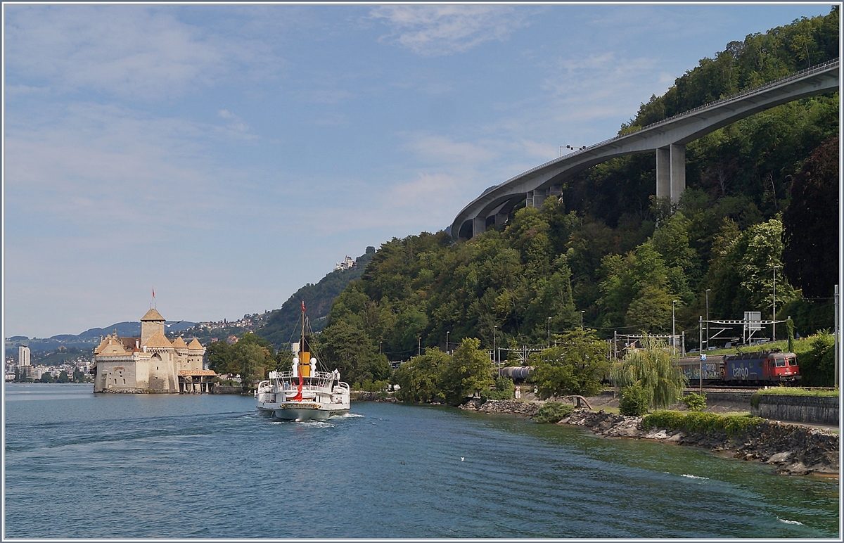 W�hrend das Dampfschiff der Anlegestelle beim Ch�teau de Chillon entgegendampft, f�hrt eine SBB Re 6/6 mit einem G�terzug Richtung Wallis.

5. August 2019