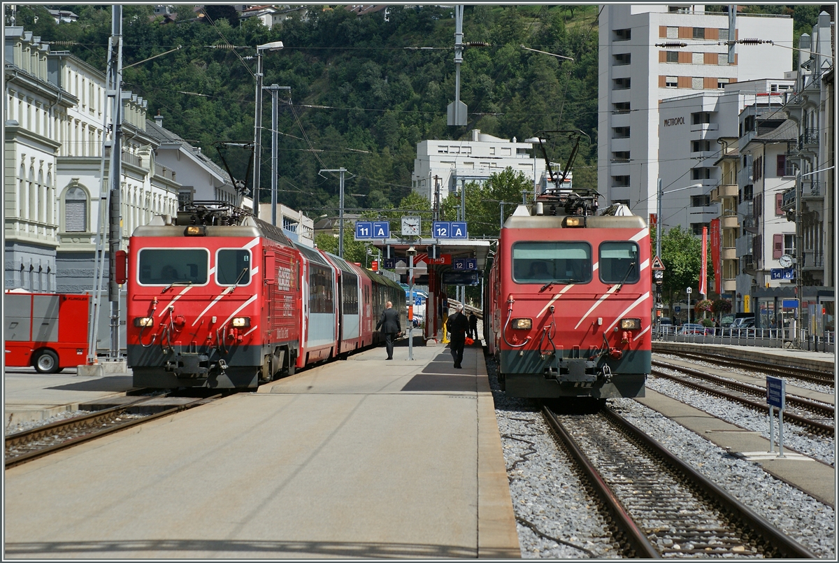 Zwei MGB HGe 4/4 warten in Brig mit einem Glacier-Express und Regionalzug Richtung Zermatt auf die Abfahrt.
16. Aug. 2014