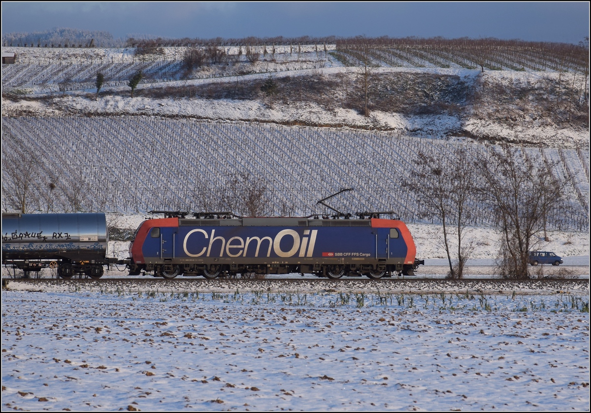 Zwischen Belchensystem und Blauendreieck. 

SBB Cargo Re 482 015 mit ChemOil-Werbung Richtung Basel bei Buggingen. Februar 2021.