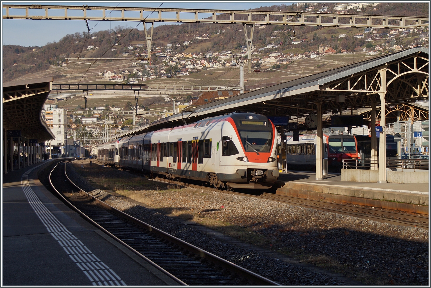 Bei einem tiefen Wintersonnenstand halten zwei SBB RABe 523 Flirt Triebzüge auf dem Weg nach St-Maurice im Bahnhof von Vevey.  

27. Dez. 2023