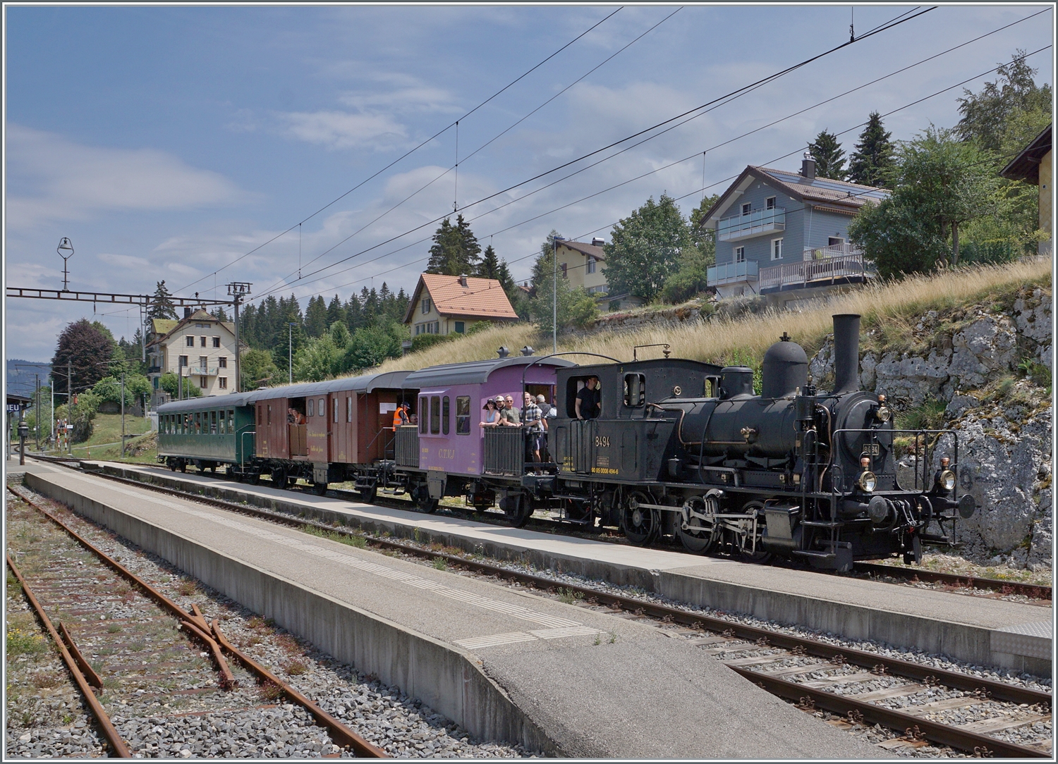 Das CTVJ (Compagnie du Train à Vapeur de la Vallée de Joux) Tigerli E 3/3 8494 (UIC 90 85 0008 494-6) der SLM mit Baujahr 1909 mit seinem CTVJ Dampfzug von Le Pont nach Le Brassus wartet in Le Lieu auf die Kreuzung mit dem den Regelzug nach Aigle; wir aber machte un auf nach Le Brasuss, um den Dampfzug dort zu empfangen. 

23. Juli 2023
