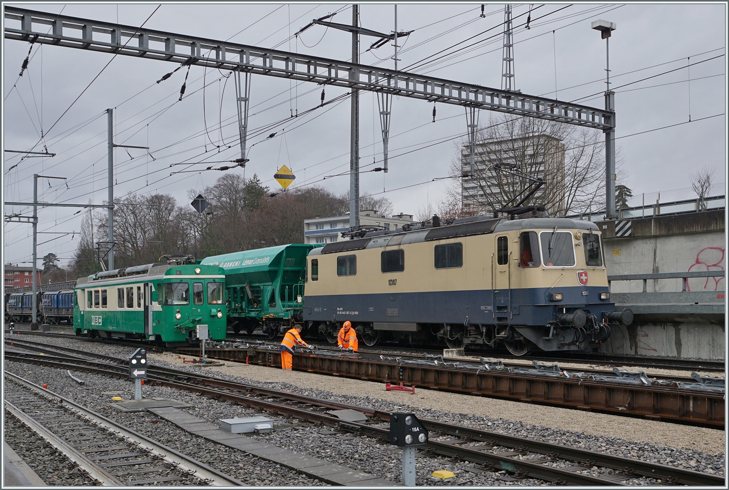 Der Bahnhof von Morges mit zwei besonderen Fahrzeugen: Da die BAM MBC SURF Be 4/4 den Passagierverkehr dominierten, sind die älteren Be 4/4 nun mehr selten zu sehen. Sie werden nach wie vor aber im Güter- und Dienstzu Verkehr eingesetzt. Neben dem Be 4/4 11 der Rollböcke rangiert, ist die IRSI Re 4/4 II 11387 (Re 421 387) zu sehen, wie sie einen Kieszug Galand - Apples auf die Rollbockanlage schiebt.

22. Februar 2024