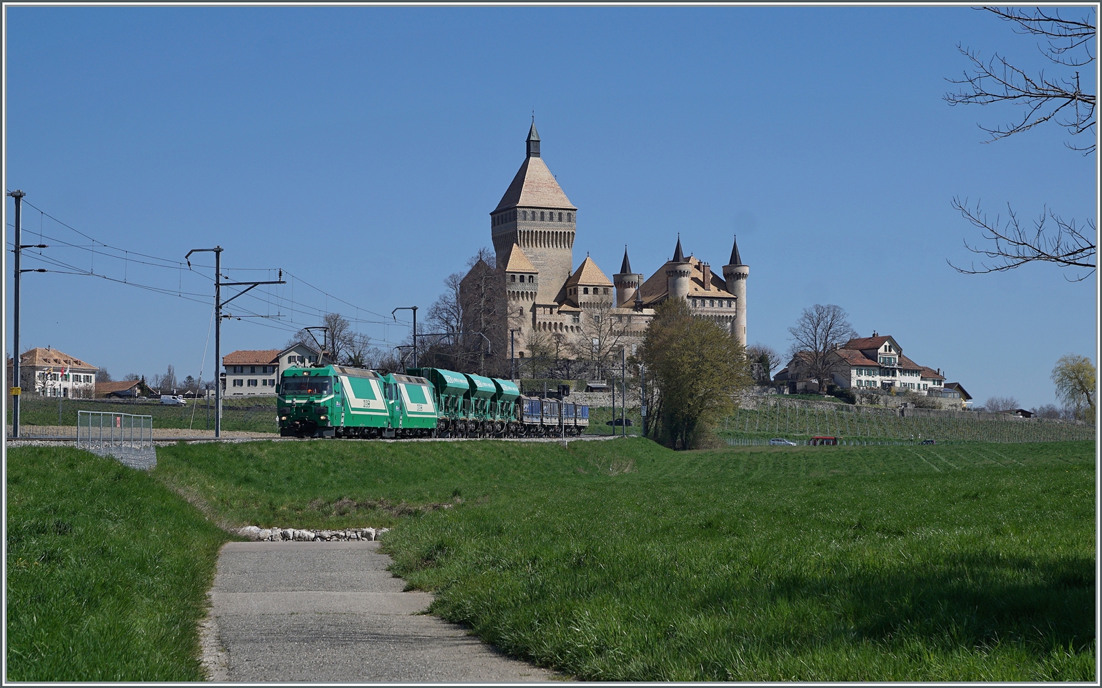 Die beiden BAM MBC Ge 4/4 21 und 22 mit ihrem Kieszug von Apples nach Gland (mit Spurwechsel in Morges) rollen beim Schloss von Vufflens vorbei.

5. April 2023