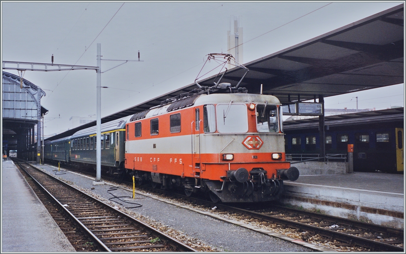 Die  Katze : eine Lok mit sieben Leben... 
Gerade in diesen Tagen wurde der Star von Balsthal zu recht häufig fotografiert, denn der Re 4/4 II 11141 steht der Swiss-Exress Anstrich sehr gut. dabei hätte die Lok verschrottet werden sollen, erhielt dann überraschend eine Revision und einen roten Anstrich verpasst. 
Und nun hat der DSF in Verdankens werter Weise der Lok wieder einen Swiss-Express Anstrich verpasst, so dass die Lok im Sonderzugeinsatz wohl noch viele Jahre zum Einsatz kommen dürfte. 

Zum Bild: Schon vor der Jahrtausendwende war die SBB Re 4/4 II 11141 in ihren Swiss Express Farbgebung (aber bereits auf ohne automatische Kupplung) ein begehrtes Motiv in mitten der meist noch grünen Reisezugwagen. Die SBB Re 4/4 II 11141 ist mit einem Schnellzug aus Lausanne in Basel SBB angekommen.

Analogbild vom 9. April 1999