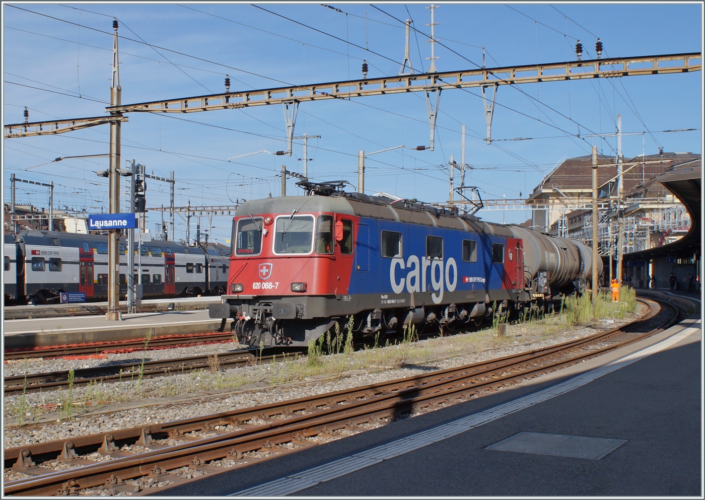 Die SBB Re 6/6 11668 (Re 620 068-7)  Stein Säckingen  hat in Lausanne die Blockdistanz zum vorausfahrenden IR 90 abgewartet und setzt sich nun mit ihrem schweren Kesselwagenzug in Bewegung. 

22. August 2024