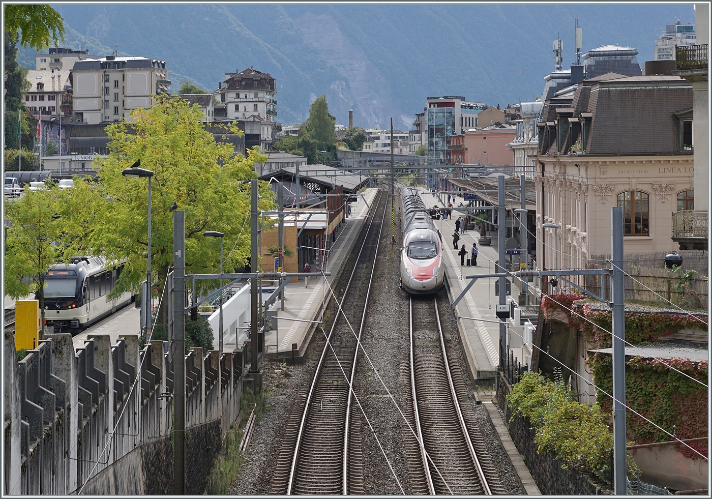 Ein SBB RABe 503 / ETR 610 als EC 32 von Milano nach Genève beim Halt im Bahnhof von Montreux, der im Normalspurteil nur aus zwei Gleisen besteht und noch über Gleiswechsel verfügt. Ganz links im Bild ist etwas verdeckt ein MOB  Alpina  zu sehen. 

25. Sept. 2024