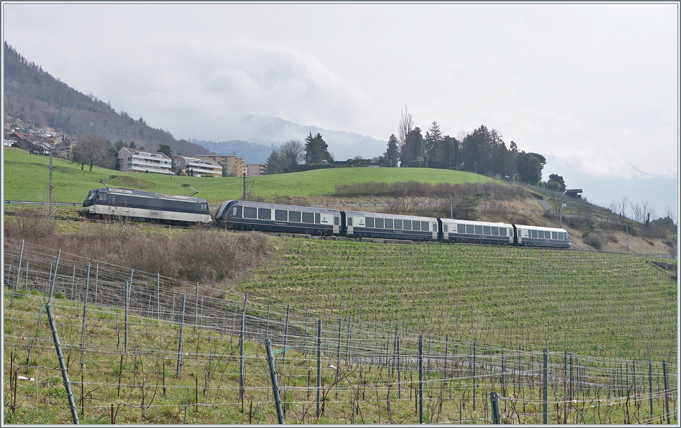 Eine MOB Ge 4/4 Serie 8000 ist mit ihrem GoldenPass Express bei Planchamp von Montreux nach Interlaken Ost unterwegs. Der Zug wurde in Zweisimmen umgespurt und von einer BLS Re 465 übernommen.

28. Feb. 2024