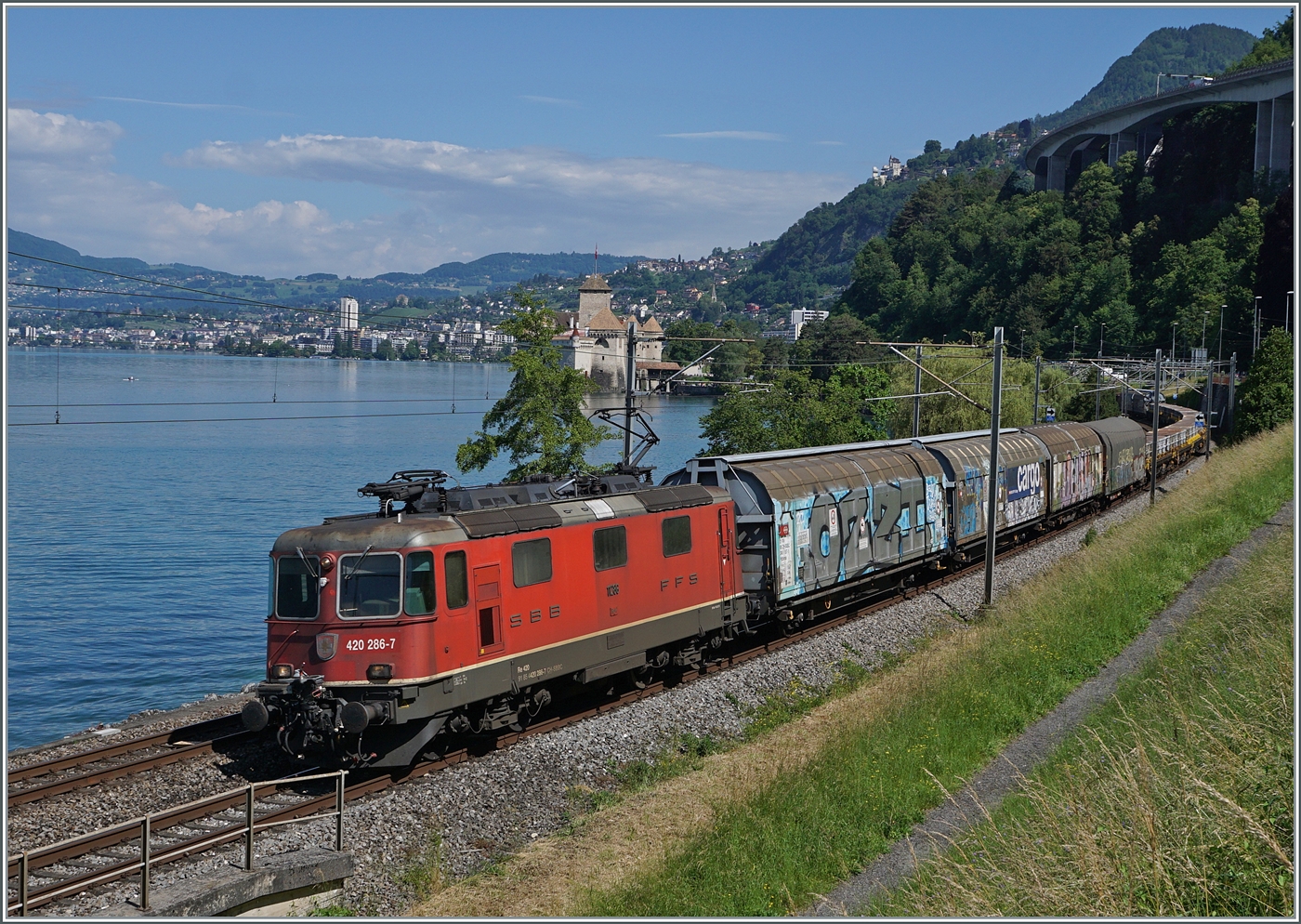 Im letzten Moment ausgelöst, noch bevor die Re 4/4 II 11286 (Re 420 286-7) vom Geländer der kleinen Brücke verdeckt wird. Die Lok ist mit einem Güterzug in Richtung Wallis unterwegs und zeigt sich bei Villeneuve vor dem Hintergrund des Château de Chillon. 

5. Juni 2024