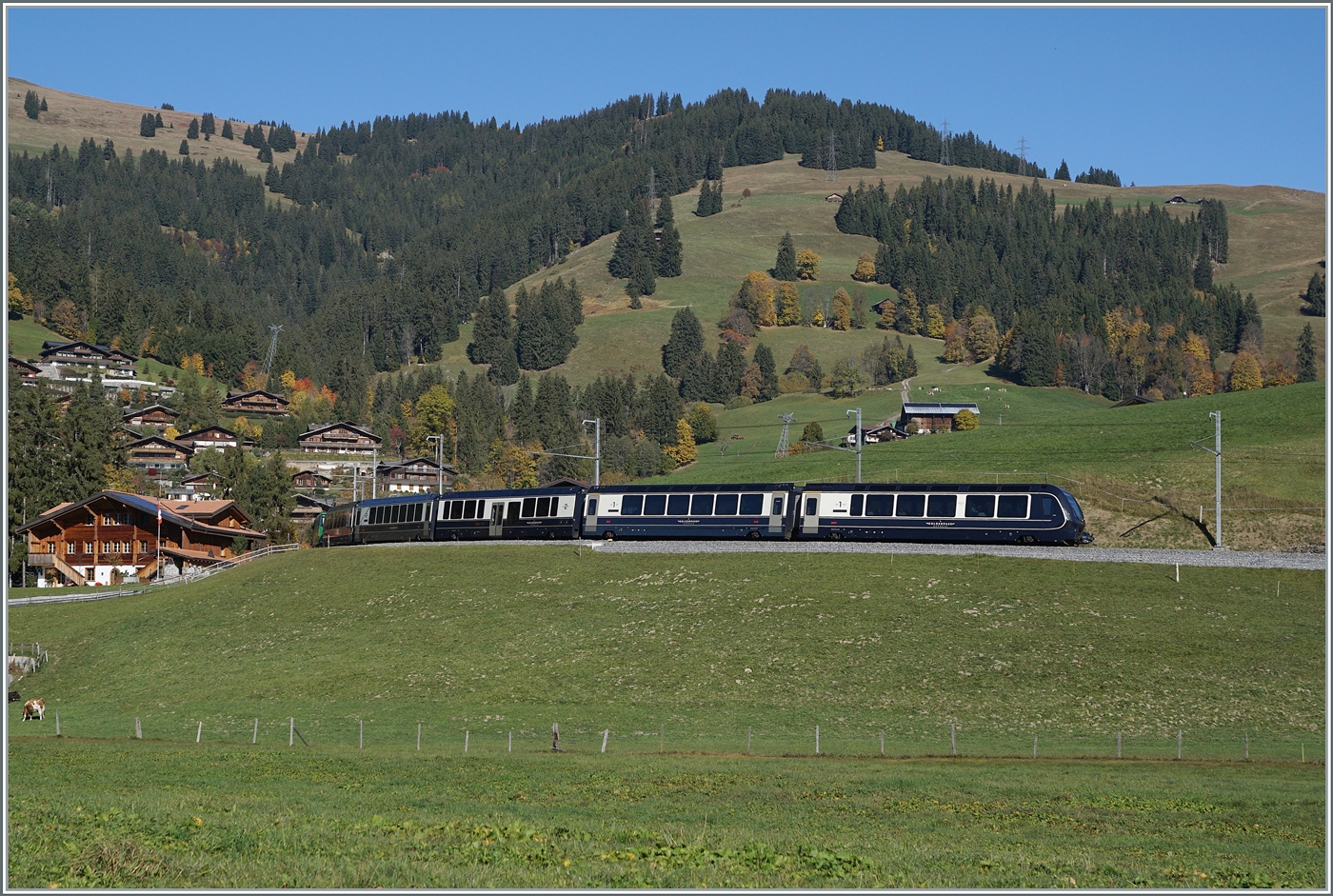 In weiten Kurven gewinnt das Trasse der MOB zwischen Gstaad und Schönried die nötige Höhe. Der GoldenPass Express (GPX) PE 4068 von Montreux nach Interlaken Ost wird in Kürze in Schönried eintreffen, an dessen Ortsrand bereits die erste schmucken Châlets zu sehen sind. 

13. OKt. 2025