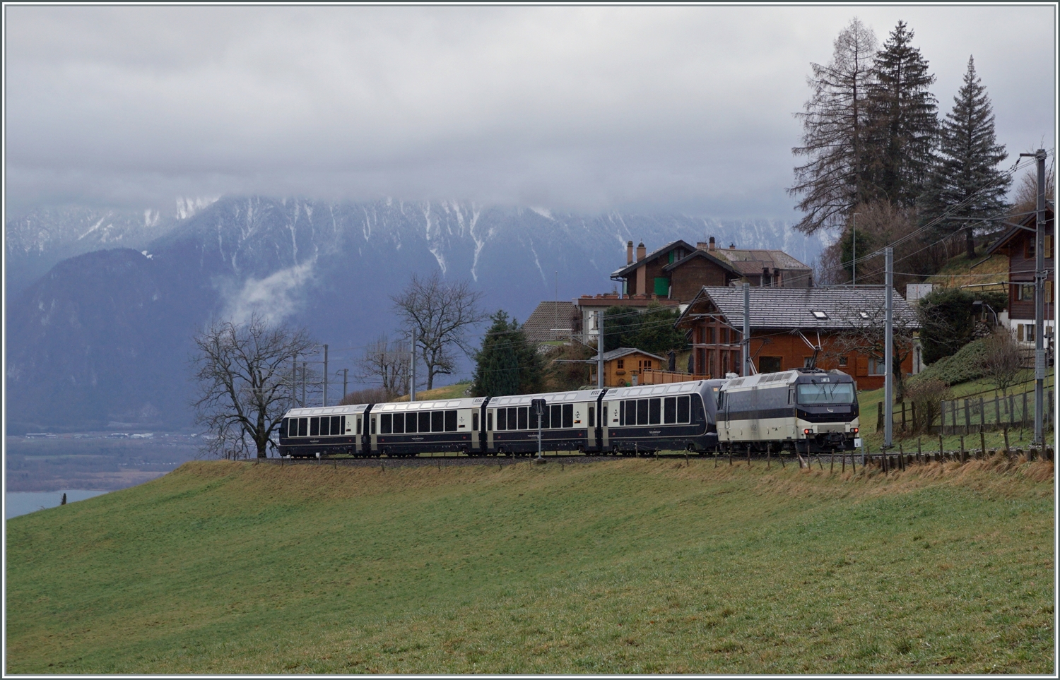 Kurz nach Les Avants ist die MOB Ge 4/4 8004 mit dem MOB/BLS GoldenPass Express GPX 4064 von Interlaken Ost nach Montreux unterwegs. Ganz Links im Bild ist der Genfersee zu sehen und somit der Höhenunterschied, welcher der GPX auf den noch verbleibenden zehn Kilometer bis Montreux zurück legen muss. 

6. Jan. 2024