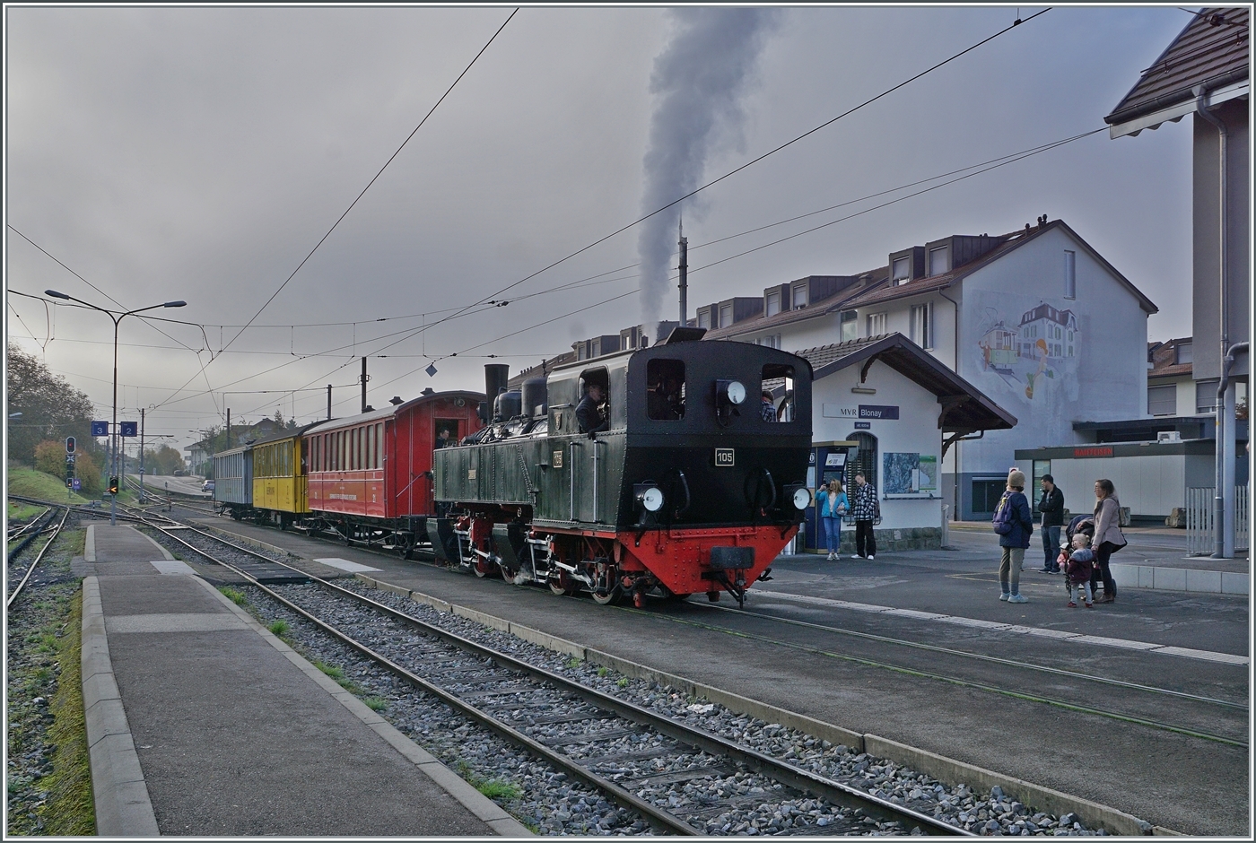 La DER de la Saison / Das Saison Ende der Blonay Chamby Bahn 2024 - Die SEG G 2x 2/2 105 der Blonay Chamby Bahn wartet mit ihrem Riviera Belle Epoque Zug auf die Abfahrt nach Vevey. 
Ebenfalls beachtenswert: Das Wandgemälde an der Hauswand rechts im Bild. Es erinnert an die CCB, Compagnie du chemin de fer Clarens–Chailly–Blonay die von 1911 bis 1955 als Überlandstrassenbahn Blonay mit Clarens verband und Thema der Blonay-Chamby Bahn Veranstaltung Les chemins de fer disparus - Die verschwundenen Bahnen im Herbst 2025 war. 

Aufnahmedatum: 27. Oktober 2024