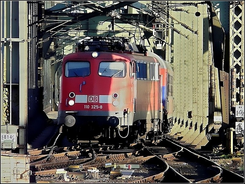 Die Bügelfalte 110 325-8 mit den blauen Farbhighlights verlässt mit Bahntouristik-Wagen die Hohenzollernbrücke und fährt in den Hauptbahnhof von Köln ein. 08.11.08 (Jeanny) 