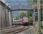 Eine SBB Re 460 ist beim Château de Chillon unter der neuen, wenig gefälligen Fussgängerbrücke zum Schloss unterwegs.