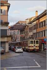 Der TPC A-L Regionalzug 329 von Leysin nach Aigle, bestehend aus dem Bt 351 und dem BDeh 4/4 302, erreichen auf der Fahrt zum Bahnhof von Aigle die Altstadt von Aigle, wo es wie zu sehen ist, ziemlich